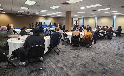 Audience watches a panel presentation at the Sowing Justice Symposium